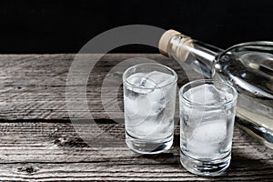 Cold vodka in shot glasses on a black background