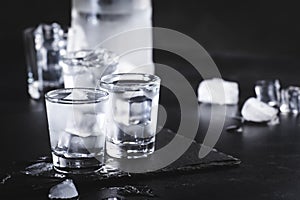 Cold Vodka in shot glasses on black background, ready to drink