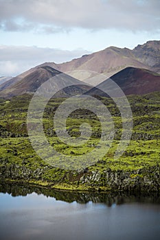 Cold water in Iceland. Stream in rocky mountains and lake side.