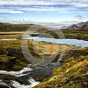 Cold water in Iceland. Stream in rocky mountains and lake side.