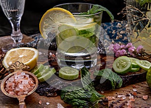 Cold water with lemon, kaffir lime, cucumber and mint leave on wooden background