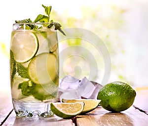 Cold water with lemon mint leaf. Fresh lemonade lime slice.