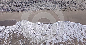 Cold waves of the Black Sea and footprints on beach sand in Pomorie, Bulgaria