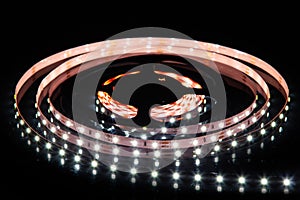 Cold white LED strip on reel with black background photo