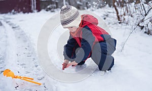 Cold white snow in childrens hands. A little boy plays with the snow