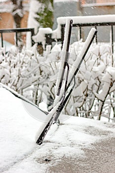 Cold winter car. Windscreen wipers covered by snow.