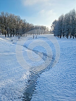 Cold winter day at sunny day - frozen river in Panevezys park Lithuania photo