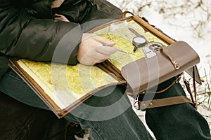 . it is cold in winter, it is snowing. Girl with a compass map and odometer in hand, paves the route. there is toning