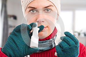 Cold woman using nasal spray at home