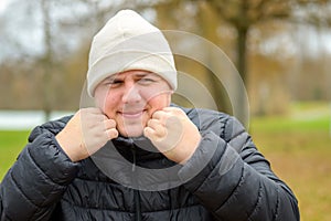 Cold young man snuggling into warm jacket