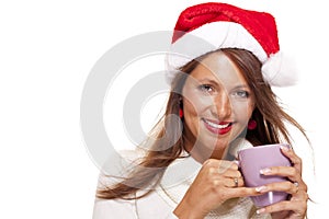 Cold young woman in a Santa hat sipping coffee tea