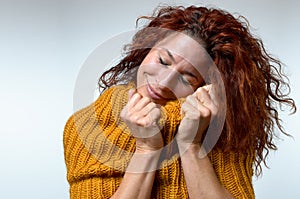 Cold young woman snuggling into a winter top