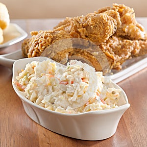 Coleslaw with fried chicken in background.