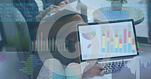 Collaborating professionals reviewing data overlays in modern lounge, with laptop charts and docs