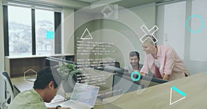 Collaborating software developers reviewing code in open-plan office, with monitors and laptop