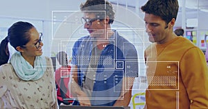 Collaborating three colleagues reviewing data overlays on laptop in open office, digital interface