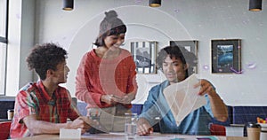 Collaborating three colleagues reviewing printed documents in meeting room, with tablet and coffee