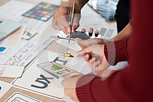 Collaboration and UX Design. Team members discussing and brainstorming UX ideas using design prototypes. photo