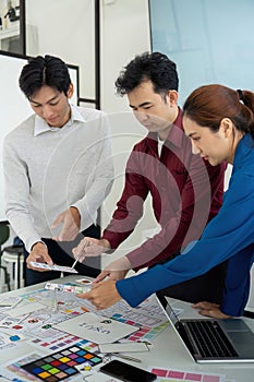 Collaborative Design Review and Strategy. Professionals assessing digital prototypes while discussing design strategy. photo
