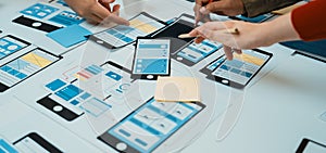 Collaborative Mobile App Design Process with Hands Working on Wireframes and Prototypes at a Table with Tools, Paper