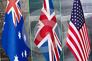 Collage of flags of Australia, the United Kingdom and the United States.