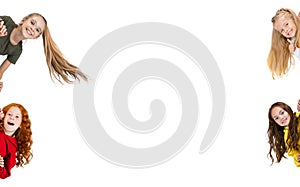 Collage of four beautiful children, cheerful girls smiling, peaking out the corner isolated over white background