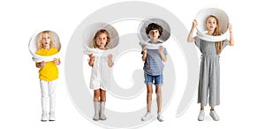 Collage of four playful joyful children, kids, boys and girl in astronaut helmets posing isolated over white background