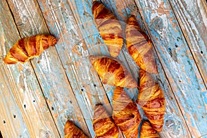 Collage of freshly baked croissants arranged aesthetically on a wooden table.