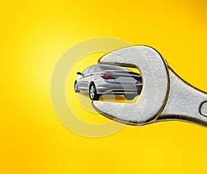 Collage, gray car in wrench isolated on yellow background