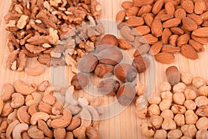 Collage of mixed nuts cashews, hazelnuts, almonds and walnuts