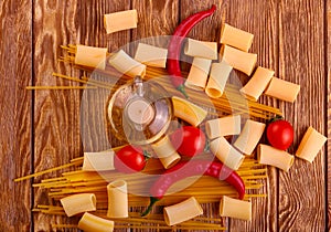 Collage Pasta with cherry tomatoes and other ingredients on wooden table background
