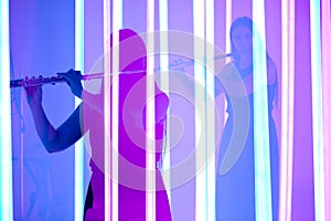 Collage of the shadows of an attractive female musician playing a flute on a wind instrument. A woman plays music