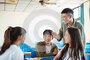 Collage Student  discuss with Classmate in Classroom photo