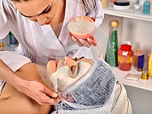 Collagen face mask. Facial skin treatment. Woman receiving cosmetic procedure.