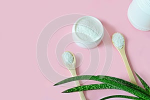 Collagen powder in bowl and measure spoon background on a pink pastel background. Natural beauty and health supplement. Flatlay,
