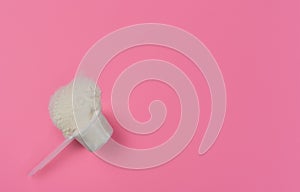 Collagen powder in a measuring spoon on a red solid background top view with copy space. Supplemental protein intake, natural