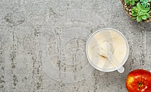 Collagen protein powder in a plastic measuring spoon and jar on a gray stone background, flat lay. Supplemental protein