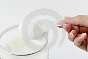 Collagen protein powder on spoon measure isolate on white background.