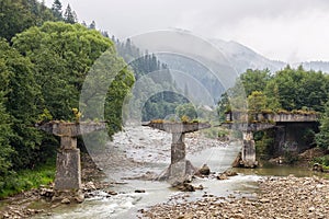 Collapsed bridge standing on a mountain river