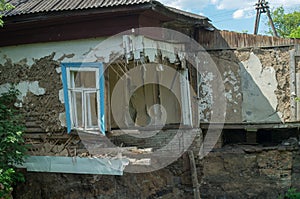 A collapsed floor in the room of a private house, fragment of the wall and window. Destruction of the foundation by groundwater.