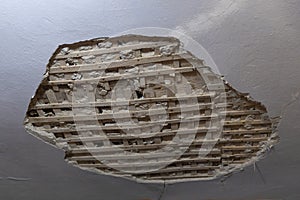 Collapsed plaster from the white ceiling in the interior of an old house