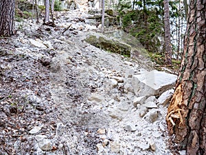 Collapsed rocky boulders fall down from sandstone rocks and landslide blocked forest path