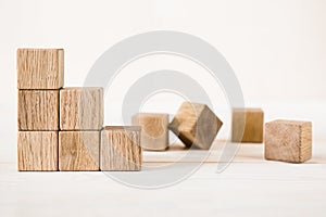 Collapsed stair structure of wooden cubes, business risk due to crisis or unsustainable financial concept photo