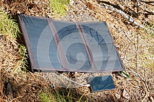 Collapsible solar panel charges a smartphone