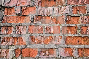 Collapsing old wall of red broken bricks, background and texture