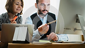 Colleague designer consultant discuss  project. Bearded businessman working at office. Director looking in monitor computer