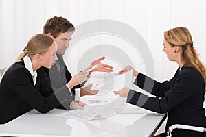 Colleague Showing Document To Businesspeople