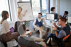 Colleague showing and explaining data on whiteboard to a group of employees. casual business, brief, meeting concept