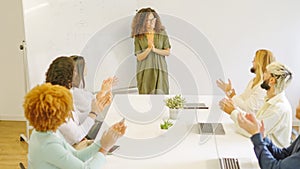 Colleagues applaud a businesswoman after a presentation