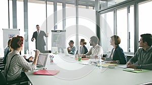 Colleagues applauding director during a meeting in conference room